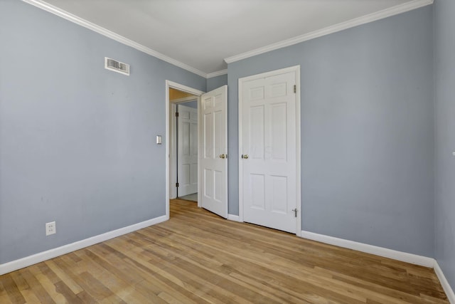 unfurnished bedroom featuring baseboards, visible vents, and light wood finished floors