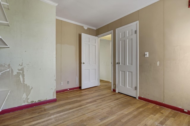 unfurnished bedroom with crown molding, baseboards, and wood finished floors