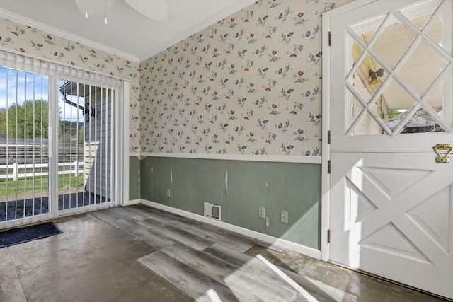 spare room featuring ceiling fan, a wainscoted wall, wallpapered walls, visible vents, and ornamental molding