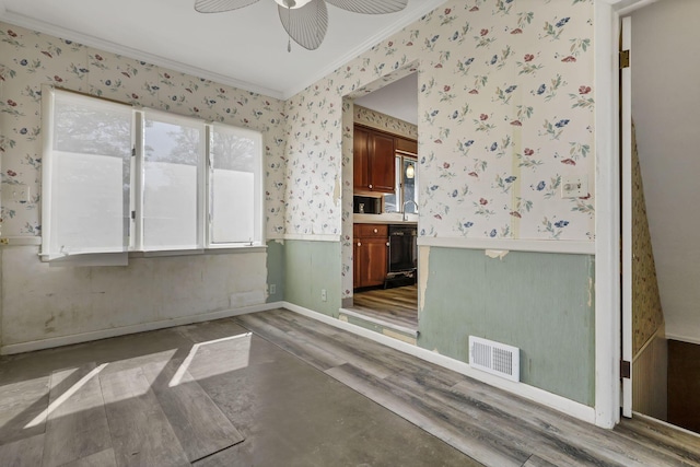 unfurnished dining area featuring crown molding, visible vents, wood finished floors, wallpapered walls, and plenty of natural light