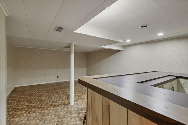 finished basement with recessed lighting, baseboards, visible vents, and a dry bar