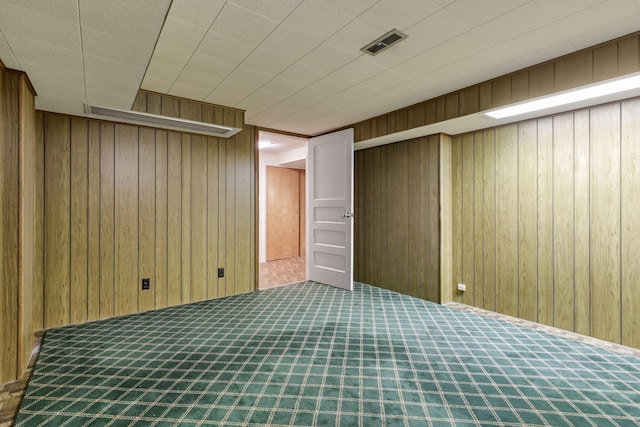 finished below grade area with carpet floors, wood walls, and visible vents