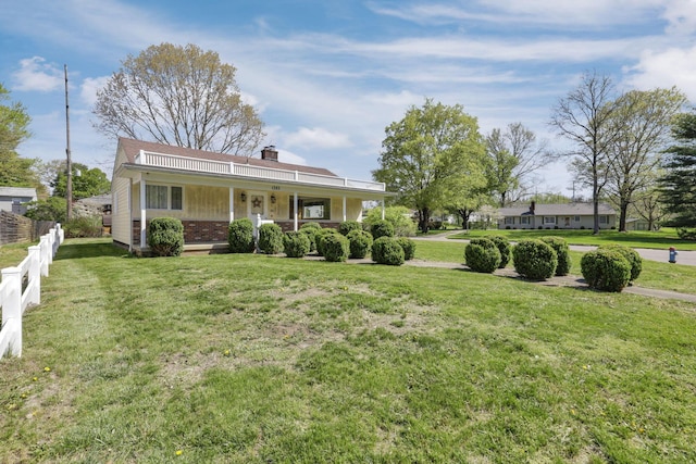 view of front facade featuring fence, covered porch, a front yard, a chimney, and brick siding