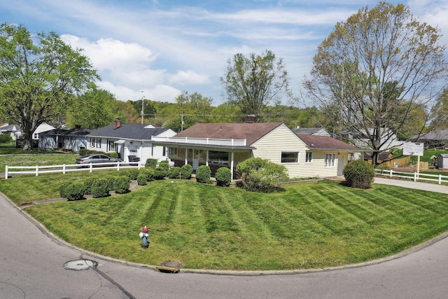 ranch-style home featuring fence, driveway, and a front yard