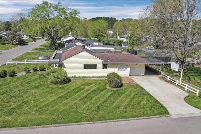view of front of home featuring fence, an attached carport, driveway, and a front lawn