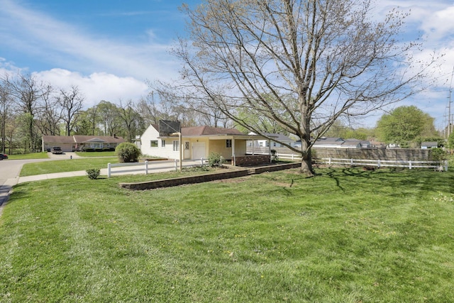 view of yard featuring fence and driveway