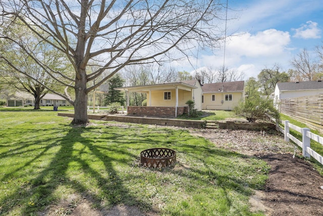 view of yard featuring a fire pit and fence