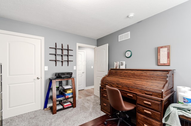 home office with baseboards, visible vents, and wood finished floors