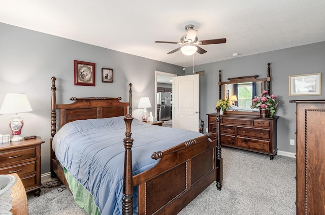 bedroom featuring stainless steel fridge, baseboards, light carpet, and a ceiling fan