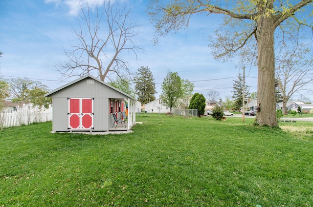 view of yard with fence, an outdoor structure, and a shed