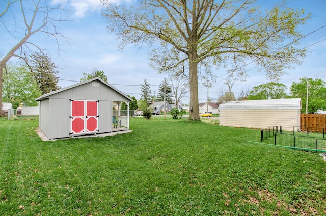 view of yard featuring an outdoor structure, a shed, and fence