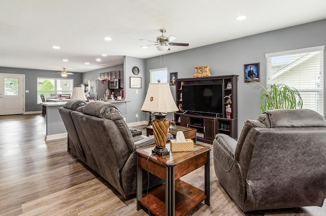living room with recessed lighting, baseboards, a ceiling fan, and light wood-type flooring