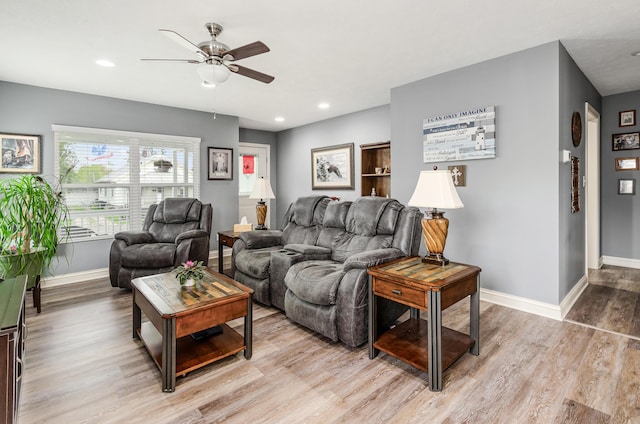 living room featuring a ceiling fan, baseboards, recessed lighting, and light wood-style flooring