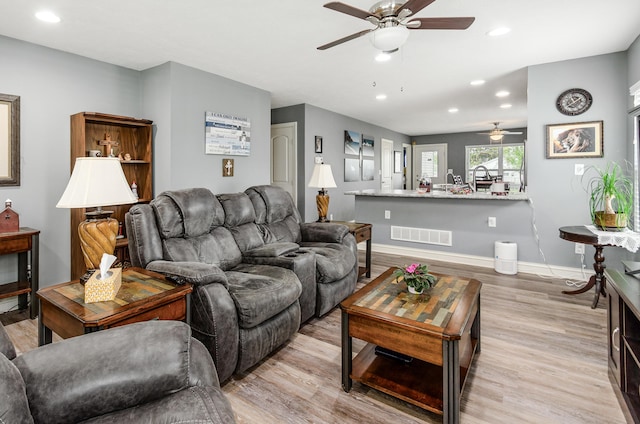 living area with light wood-style flooring, a ceiling fan, baseboards, recessed lighting, and visible vents