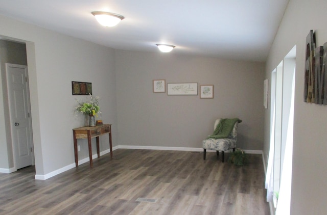 sitting room with baseboards and wood finished floors