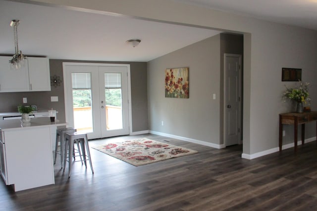 dining space with french doors, baseboards, dark wood-type flooring, and lofted ceiling