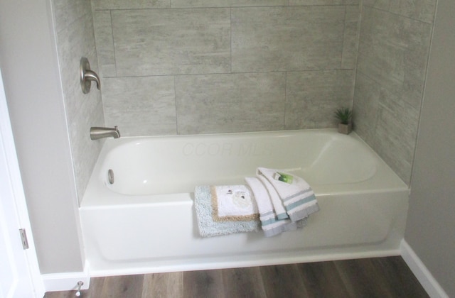 full bathroom featuring baseboards and a bathtub