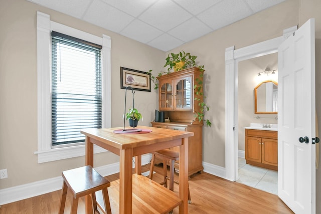 54 E Smiley Ave, Shelby, OH 44875 - dining room with light wood-style floors, baseboards, a drop ceiling, and a healthy amount of sunlight