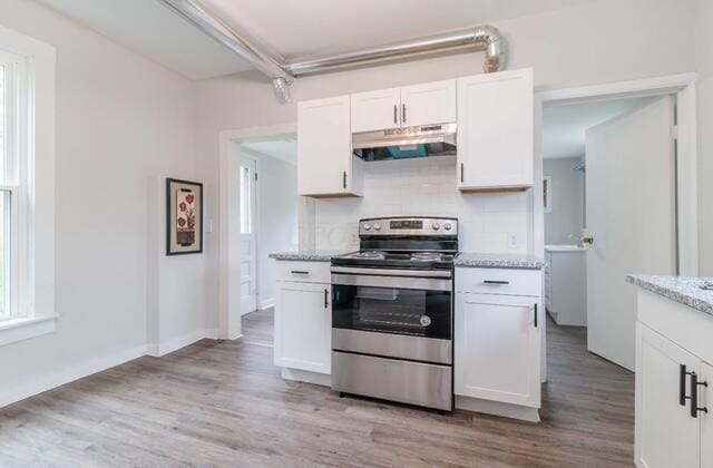 kitchen with decorative backsplash, electric range, light wood-type flooring, white cabinets, and under cabinet range hood