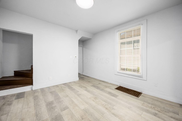 interior space featuring stairs, baseboards, visible vents, and wood finished floors
