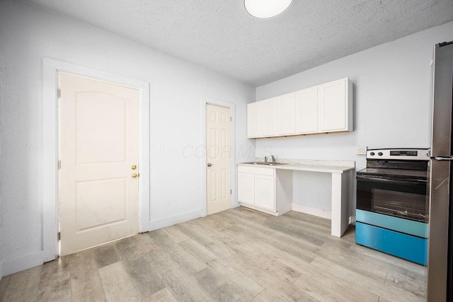 kitchen with light wood-style floors, electric range, and white cabinetry
