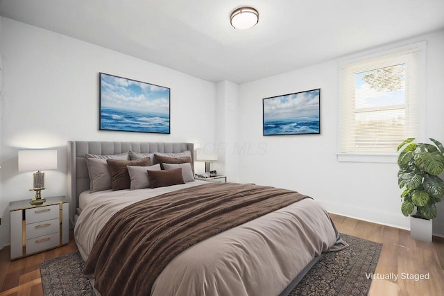 bedroom with baseboards and wood finished floors