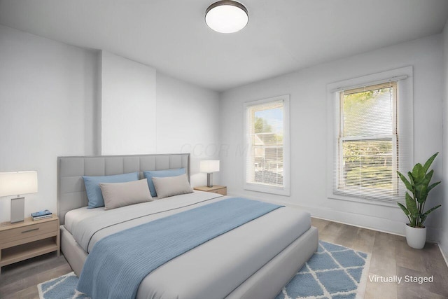 bedroom with baseboards and wood finished floors