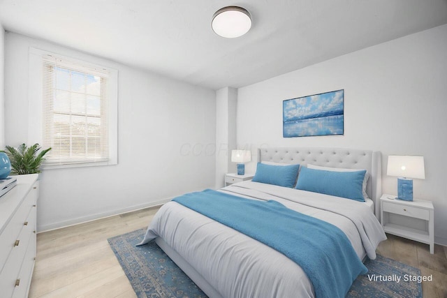 bedroom featuring baseboards and light wood-style flooring