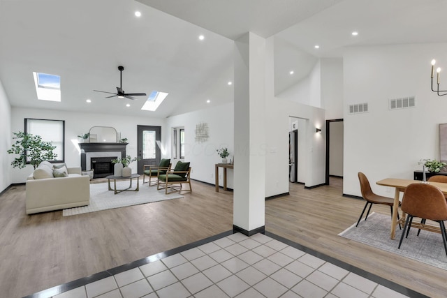 845 Mcnaughten Rd, Columbus, OH 43213 - living room featuring a skylight, visible vents, a glass covered fireplace, and light wood-style flooring