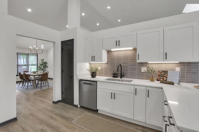 845 Mcnaughten Rd, Columbus, OH 43213 - kitchen featuring stainless steel dishwasher, a sink, white cabinetry, and a notable chandelier