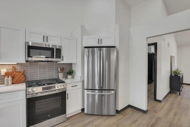 845 Mcnaughten Rd, Columbus, OH 43213 - kitchen featuring backsplash, light wood-type flooring, light countertops, stainless steel appliances, and white cabinetry