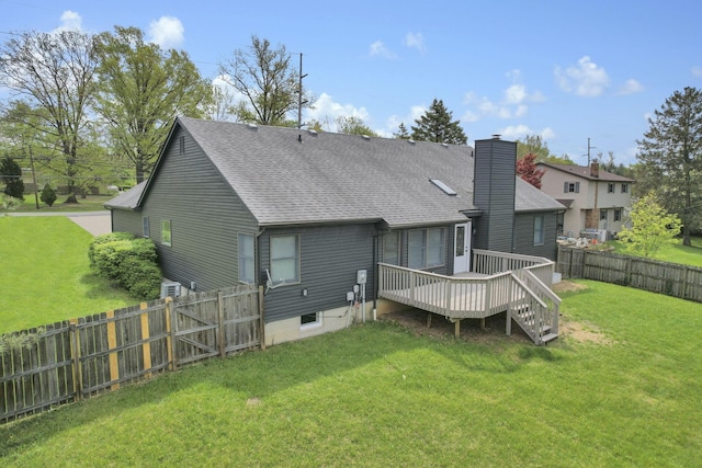 845 Mcnaughten Rd, Columbus, OH 43213 - back of property featuring a wooden deck, a fenced backyard, a chimney, a shingled roof, and a lawn