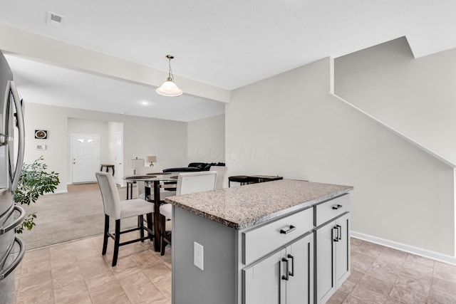 5837 Mouzon Dr, Columbus, OH 43232 - kitchen featuring a center island, visible vents, baseboards, decorative light fixtures, and stainless steel refrigerator