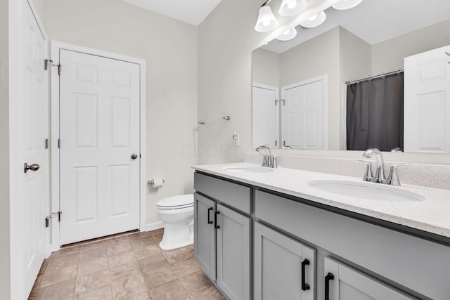 5837 Mouzon Dr, Columbus, OH 43232 - full bath featuring toilet, baseboards, double vanity, and a sink