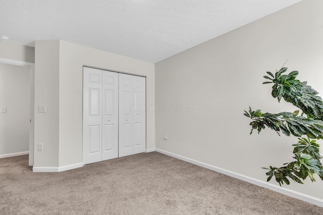 5837 Mouzon Dr, Columbus, OH 43232 - unfurnished bedroom with baseboards, a textured ceiling, a closet, and carpet floors