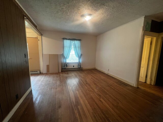 unfurnished room with a textured ceiling, baseboard heating, baseboards, a baseboard radiator, and hardwood / wood-style floors