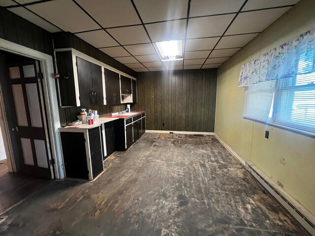 bar with wooden walls, baseboards, a baseboard heating unit, and a drop ceiling