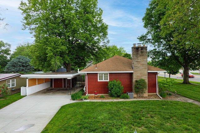 125 S Hamilton Rd, Columbus, OH 43230 - view of front of property featuring concrete driveway, a carport, a front yard, a chimney, and a shingled roof
