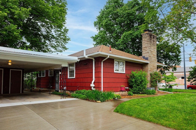 125 S Hamilton Rd, Columbus, OH 43230 - view of side of home with a chimney, concrete driveway, and a yard