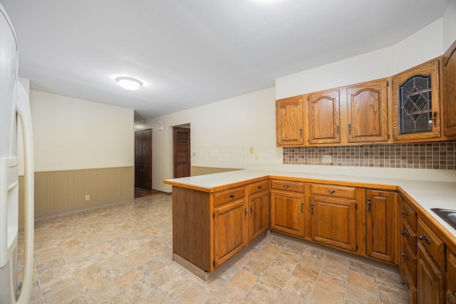 125 S Hamilton Rd, Columbus, OH 43230 - kitchen with a peninsula, freestanding refrigerator, brown cabinets, light countertops, and stone finish flooring