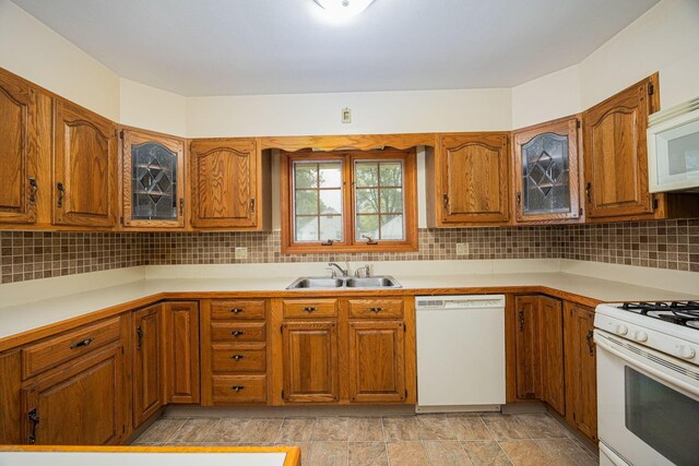 125 S Hamilton Rd, Columbus, OH 43230 - kitchen with white appliances, a sink, brown cabinetry, glass insert cabinets, and tasteful backsplash