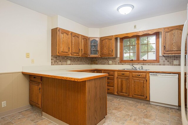 125 S Hamilton Rd, Columbus, OH 43230 - kitchen featuring dishwasher, a sink, brown cabinets, a peninsula, and stone finish floors