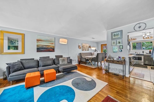 living area with crown molding and wood finished floors