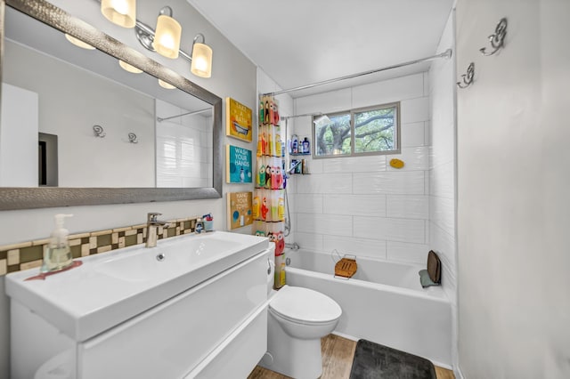 bathroom with vanity, toilet, wood finished floors, and shower / tub combo