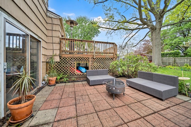 view of patio with fence, a wooden deck, and an outdoor fire pit