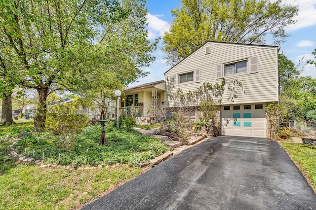 tri-level home featuring a garage and aphalt driveway