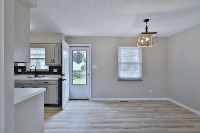 1235 Beechwood Rd, Columbus, OH 43227 - kitchen with light countertops, a chandelier, light wood finished floors, decorative light fixtures, and a textured ceiling
