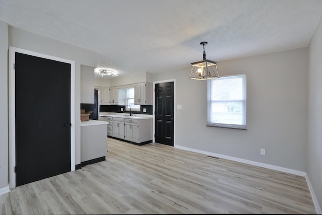 1235 Beechwood Rd, Columbus, OH 43227 - kitchen featuring light countertops, a chandelier, light wood finished floors, freestanding refrigerator, and pendant lighting