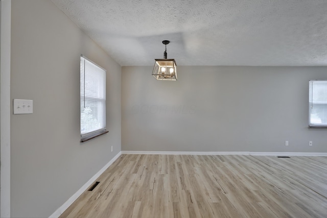 1235 Beechwood Rd, Columbus, OH 43227 - spare room featuring light wood finished floors, a textured ceiling, and a chandelier