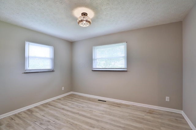 1235 Beechwood Rd, Columbus, OH 43227 - empty room with light wood-style flooring and a textured ceiling